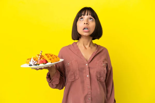 Pregnant Woman Holding Waffles Isolated Yellow Background Looking Surprised Expression — Stock Fotó