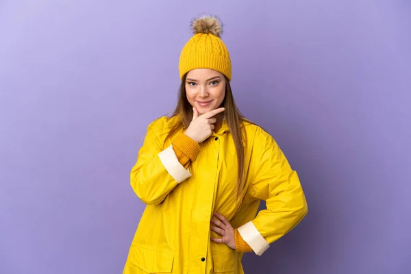 Chica Adolescente Con Abrigo Impermeable Sobre Fondo Púrpura Aislado Pensando —  Fotos de Stock