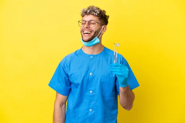 Dentista Caucasiano Homem Segurando Ferramentas Isoladas Fundo Amarelo Rindo — Fotografia de Stock