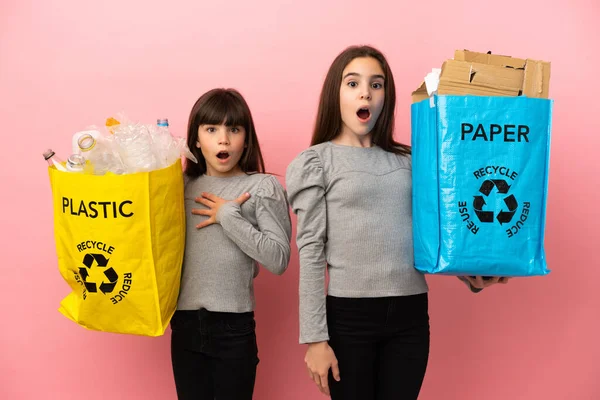 Küçük Kız Kardeşler Geri Dönüşüm Kağıtlarını Plastikleri Pembe Arka Planda — Stok fotoğraf