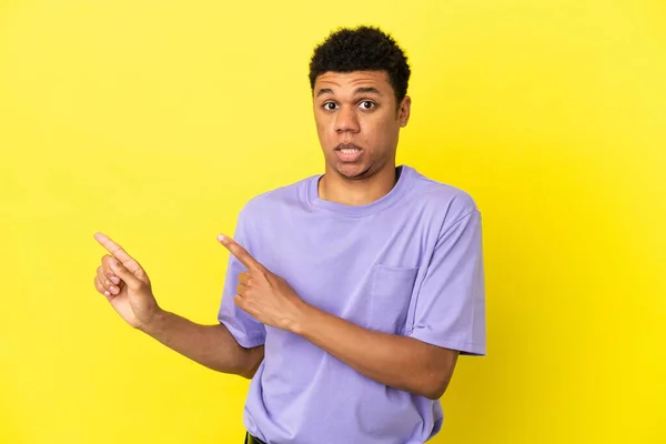 Jonge Afro Amerikaanse Man Geïsoleerd Gele Achtergrond Bang Wijst Naar — Stockfoto