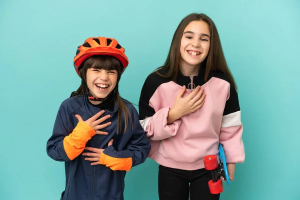 Hermanitas Practicando Ciclismo Patinadora Aisladas Sobre Fondo Azul Sonriendo Mucho —  Fotos de Stock
