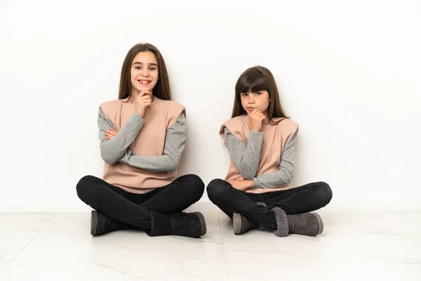 Irmãzinhas Sentadas Chão Isoladas Fundo Branco Sorrindo Olhando Para Frente — Fotografia de Stock