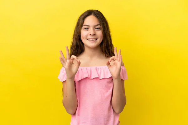 小さなCaucasian女の子絶縁上の黄色の背景ショーOk Signとともに二本の手 — ストック写真