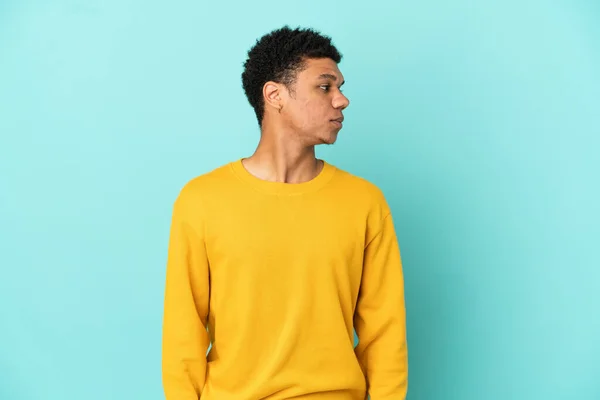 Junger Afroamerikanischer Mann Isoliert Auf Blauem Hintergrund Der Zur Seite — Stockfoto