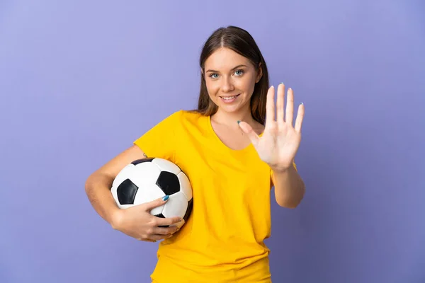 年轻的立陶宛足球女运动员被隔离在紫色背景下 用手指数着5 — 图库照片