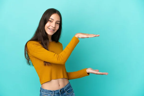 Joven Francesa Aislada Sobre Fondo Azul Sosteniendo Copyspace Para Insertar —  Fotos de Stock