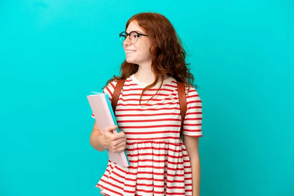 Student Teenager Redhead Girl Isolated Blue Background Looking Side Smiling — Stock Photo, Image