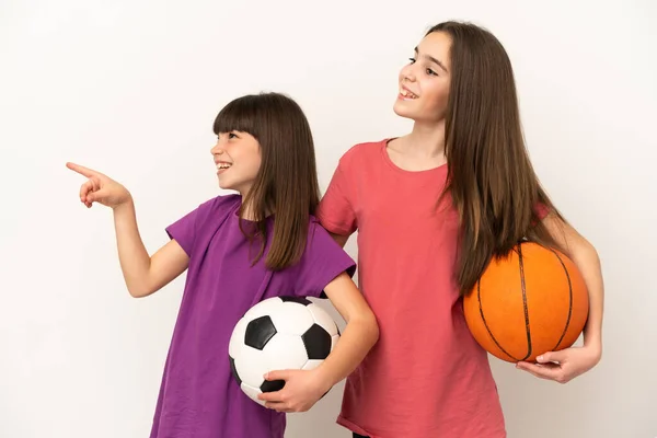 축구와 농구를 자매들은 배경에서 고립된 웃으면서 아이디어를 제시하고 있습니다 — 스톡 사진