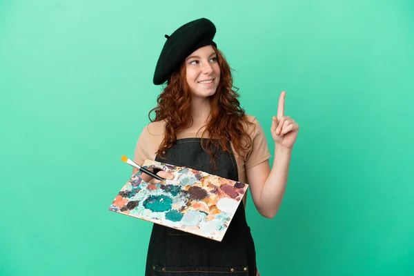 Teenager Redhead Artist Holding Palette Isolated Green Background Pointing Great — Stock Photo, Image