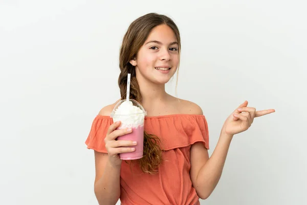 小さなCaucasian女の子とともにイチゴミルクシェイク孤立上の白い背景指差し指へ側 — ストック写真