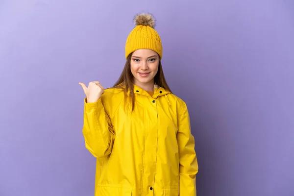 Menina Adolescente Vestindo Uma Capa Impermeável Sobre Fundo Roxo Isolado — Fotografia de Stock