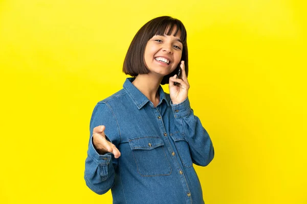 Mujer Embarazada Usando Teléfono Móvil Aislado Sobre Fondo Amarillo Estrechando —  Fotos de Stock