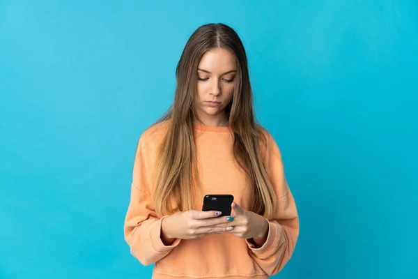 Молодая Литовская Женщина Изолирована Синем Фоне Помощью Мобильного Телефона — стоковое фото