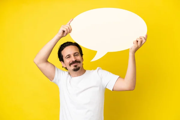 stock image Young caucasian man isolated on yellow background holding an empty speech bubble