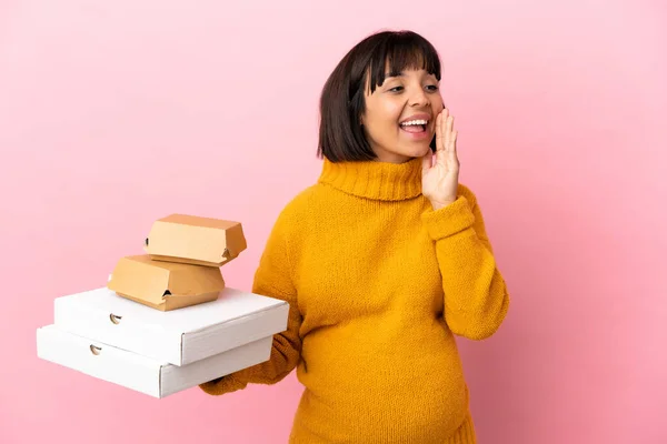 Schwangere Hält Pizzen Und Burger Isoliert Auf Rosa Hintergrund Schreit — Stockfoto