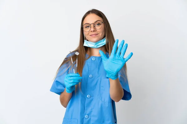 立陶宛女牙医在孤立的背景下拿着工具 用手指数着5 — 图库照片