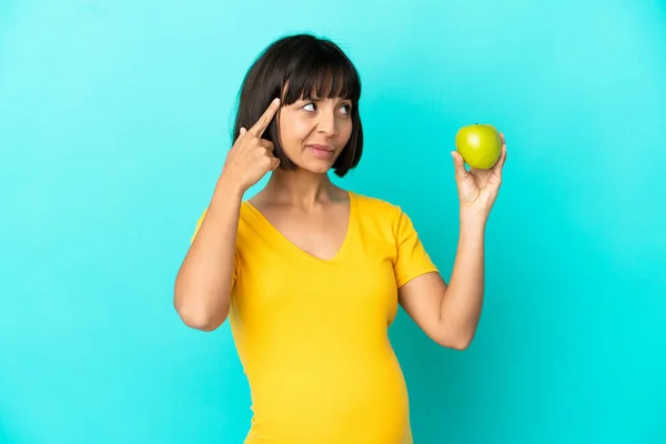 Schwangere Mit Einem Apfel Auf Blauem Hintergrund Die Zweifel Hat — Stockfoto