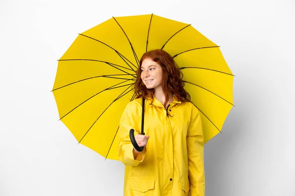 ティーンRedhead女の子レインプルーフコートと傘隔離された上に白の背景見に側と笑顔 — ストック写真