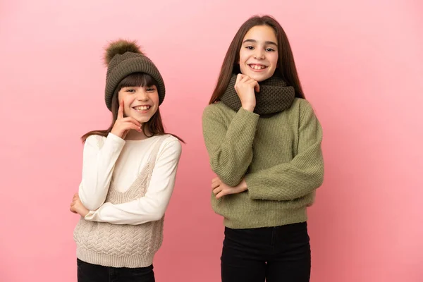 Hermanitas Vestidas Con Ropa Invierno Aisladas Sobre Fondo Rosa Sonriendo —  Fotos de Stock