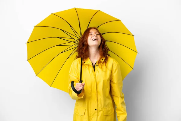 ティーンRedhead女の子レインプルーフコートと傘孤立した上に白の背景笑い — ストック写真
