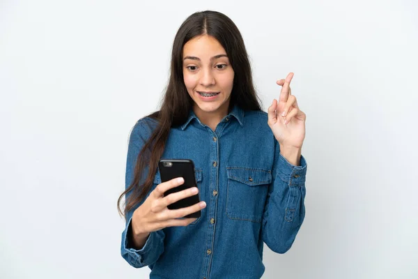 Молодая Француженка Изолирована Белом Фоне Помощью Мобильного Телефона Скрещенными Пальцами — стоковое фото
