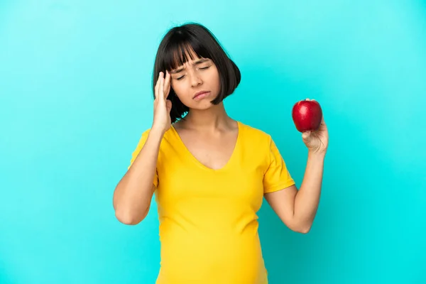Schwangere Mit Einem Apfel Auf Blauem Hintergrund Und Kopfschmerzen — Stockfoto