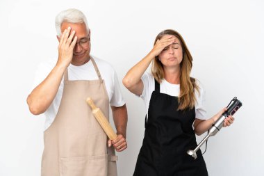 Orta yaşlı aşçılar beyaz arka planda, şaşırmış ve şok olmuş bir yüz ifadesine sahipler.