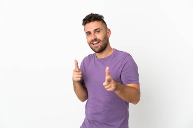 Beyaz arka planda izole edilmiş beyaz bir adam ön tarafı işaret ediyor ve gülümsüyor.