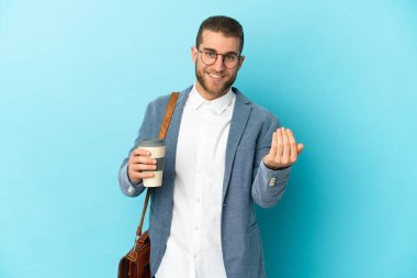 Kafkasyalı genç işadamı, mavi arka planda izole edilmiş bir şekilde el ele gelmeye davet ediyor. Gelmene sevindim.