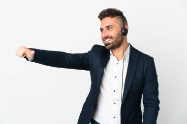 Tele pazarlamacı beyaz arka planda izole edilmiş bir kulaklıkla çalışıyor.