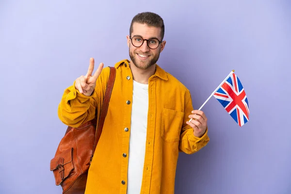 Mladý Běloch Drží Vlajku Spojeného Království Izolované Fialovém Pozadí Úsměvem — Stock fotografie
