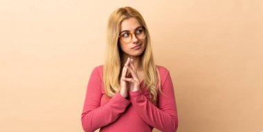 Genç Uruguaylı sarışın kadın izole bir arka plan entrikası kuruyor.