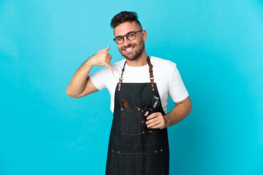 Önlüklü bir berber telefon jesti yapıyor. Bana geri dönüş işareti ver.