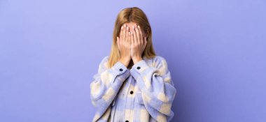 Genç Uruguaylı sarışın kadın izole edilmiş arka planda gözlerini elleriyle kapatıyor.