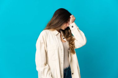 Kafkasyalı genç bir kadın mavi arka planda izole edilmiş, baş ağrısı var.