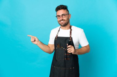 Önlüklü berber parmağını yana doğru gösteriyor.