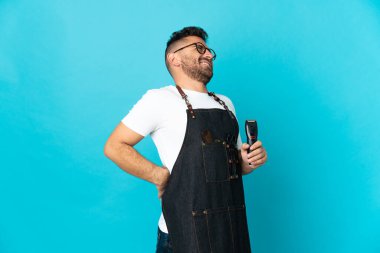 Önlüklü berber, gayret gösterdiği için sırt ağrısı çekiyor.