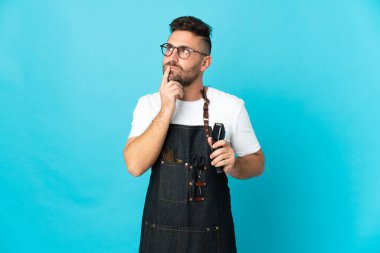 Önlüklü berberin yukarı bakarken şüpheleri var.