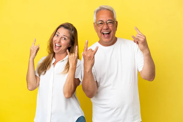 Coppia Mezza Età Isolata Sfondo Giallo Facendo Gesto Rock — Foto Stock