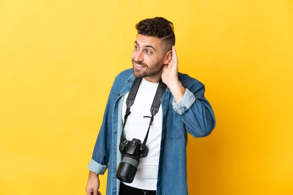 Photographer Man Isolated Yellow Background Listening Something Putting Hand Ear — Stock Photo, Image