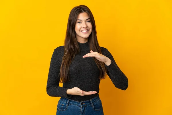 Adolescente Menina Brasileira Isolada Fundo Amarelo Segurando Espaço Imaginário Palma — Fotografia de Stock