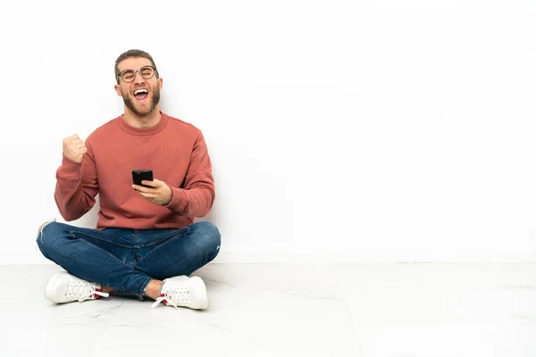 Young Handsome Man Sitting Floor Phone Victory Position — Stock Photo, Image