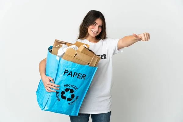 白い背景に隔離された紙をリサイクルするためにリサイクルバッグを持っている若い女性は ジェスチャーを親指アップ与えます — ストック写真