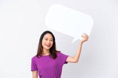 Beyaz arka planda izole edilmiş genç Vietnamlı kadın boş bir konuşma balonu tutuyor.