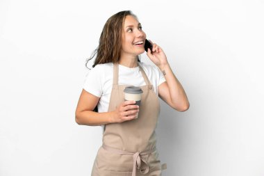 Restoran garsonu, beyaz arka planda izole edilmiş beyaz bir kadın. Elinde kahve ve cep telefonu var.