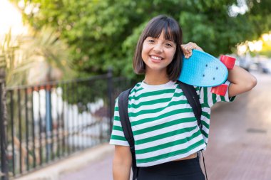 Açık havada patenli esmer bir kadın.