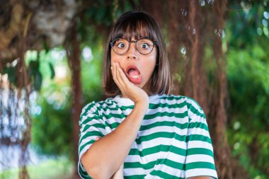 Parktaki genç esmer kadın sağa bakarken şaşırdı ve şok oldu.