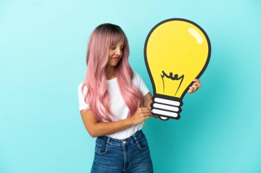 Mavi arka planda izole edilmiş pembe saçlı melez bir kadın elinde bir ampul simgesi ve şüpheleri var.