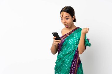 Beyaz arka planda izole edilmiş genç Hintli kadın şaşırdı ve bir mesaj gönderiyor.